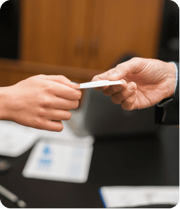 Une personne donnant sa carte de visite à une autre personne